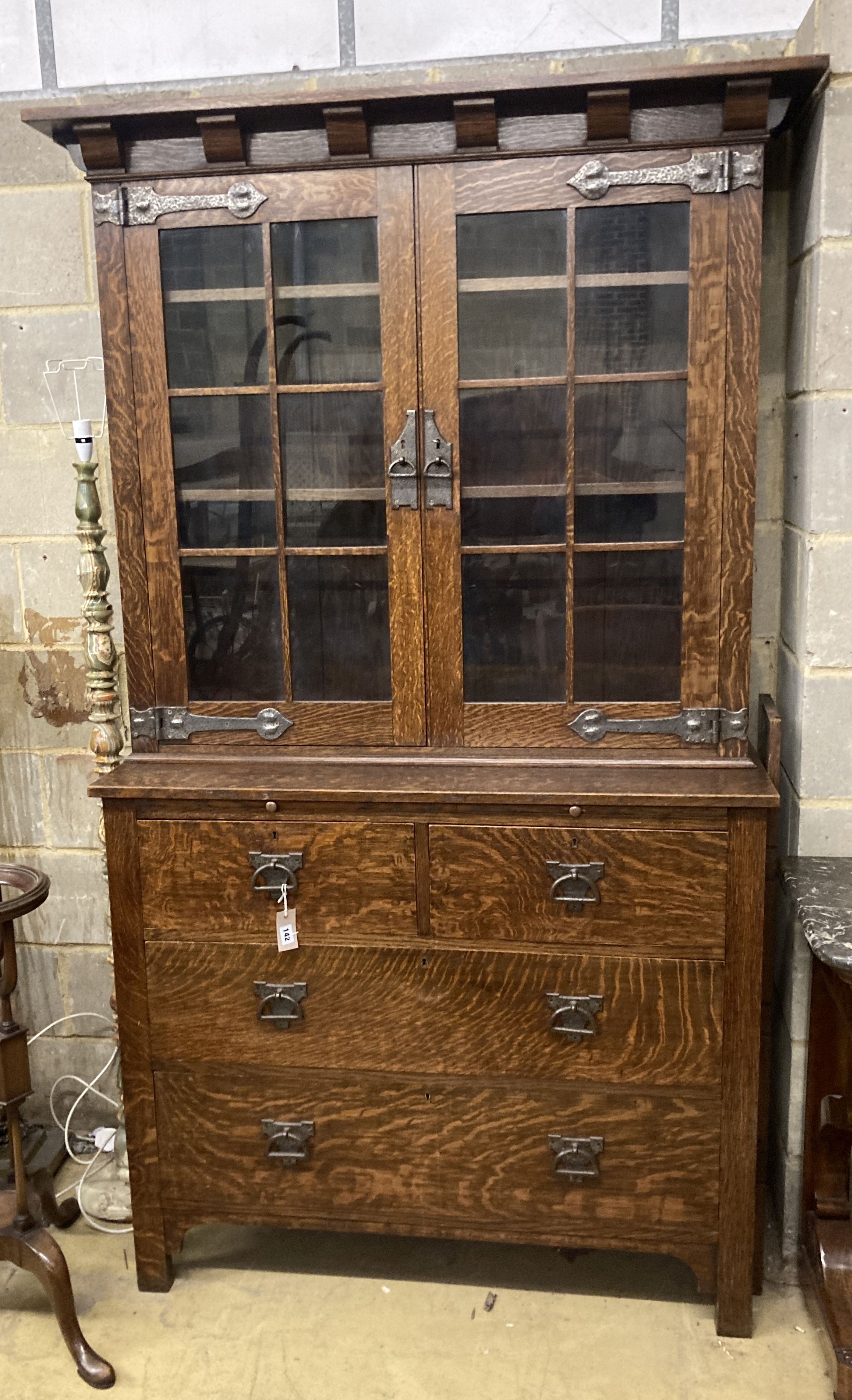 An early 20th century Arts and Crafts oak bookcase on chest, width 114cm, depth 48cm, height 208cm